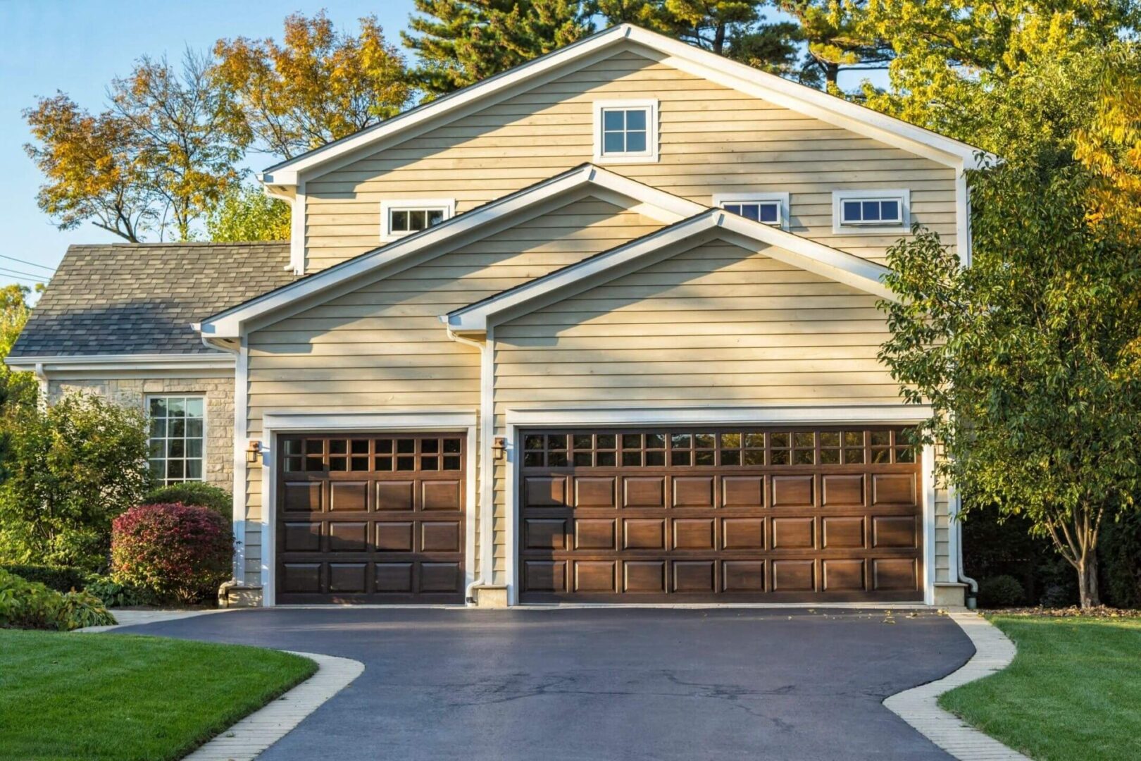 A two car garage with wooden doors and metal windows.