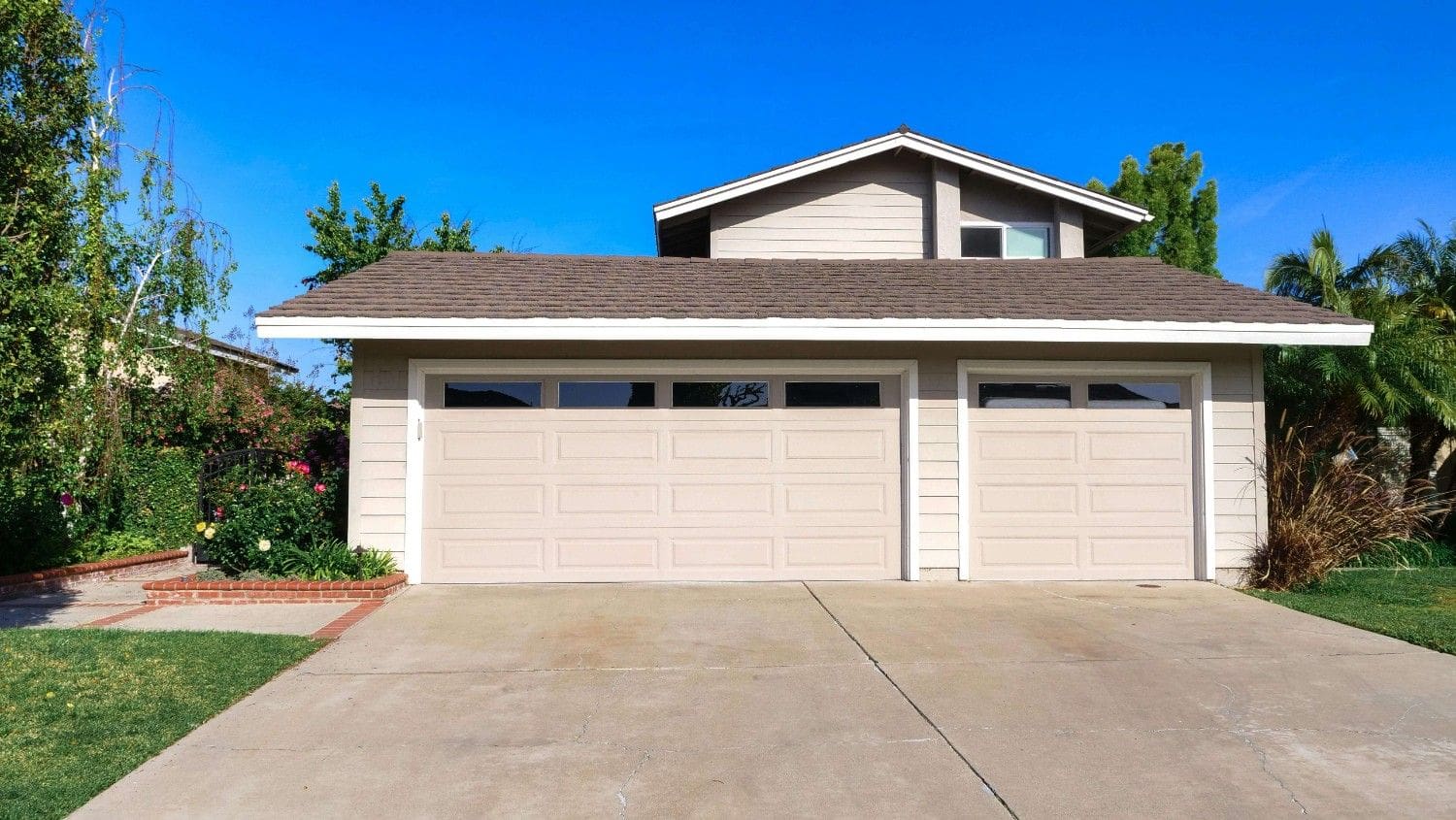 A large garage with two doors and a driveway.